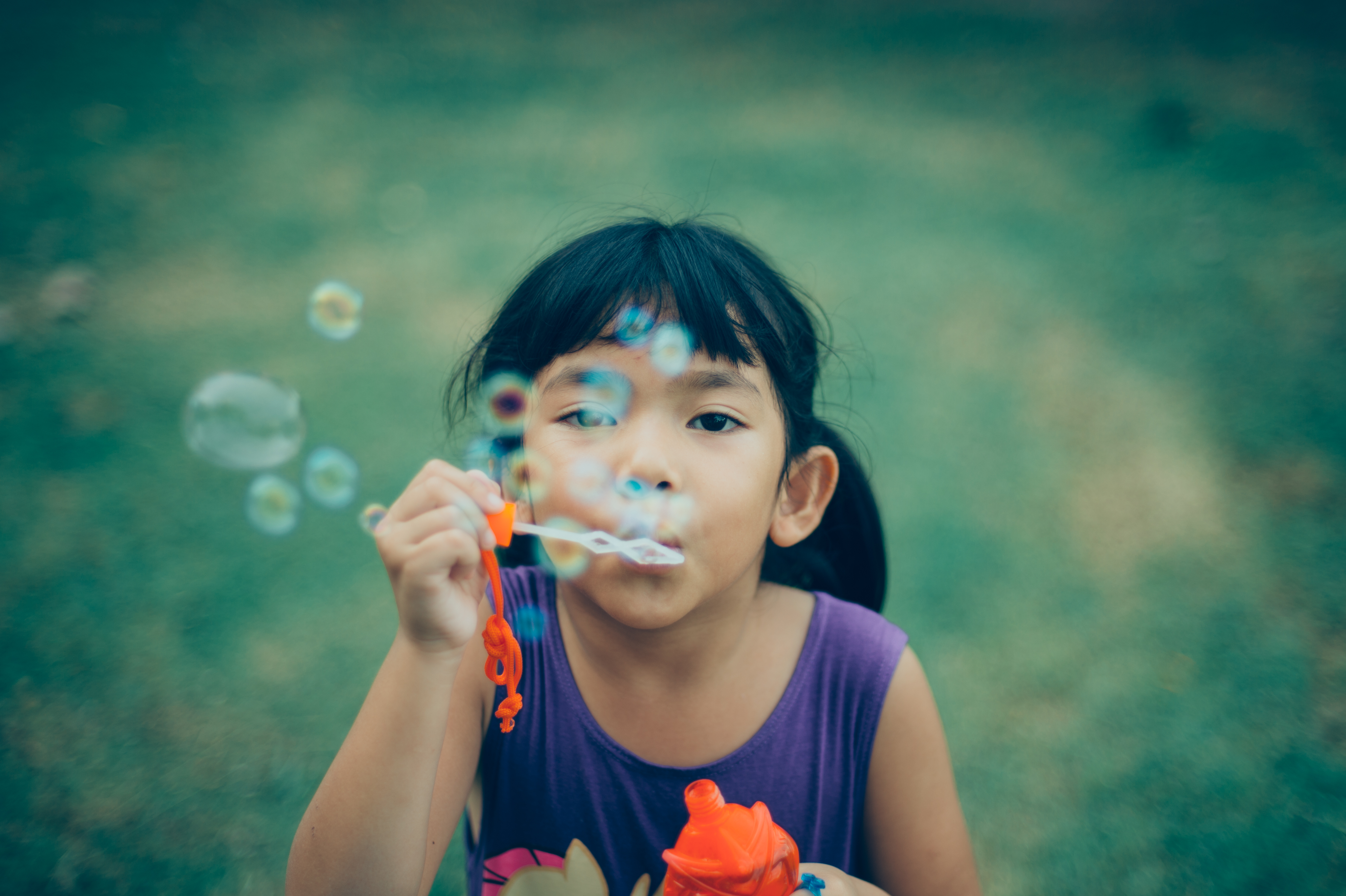 child blowing bubbles